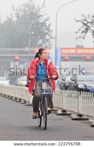 BEIJING-OCT. 11 ,2014. Elderly cycles in smog blanketed city. A concentration of PM2.5, small particles that poses a huge health risk, hit 462 according the U.S. Embassy pollution monitor in Beijing.