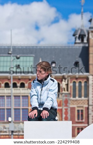 AMSTERDAM-AUGUST 24, 2014. Girl on top of a sculpture at Rijksmuseum. It is a national museum dedicated to arts and history, located at Museum Square close to Van Gogh Museum and Stedelijk Museum.