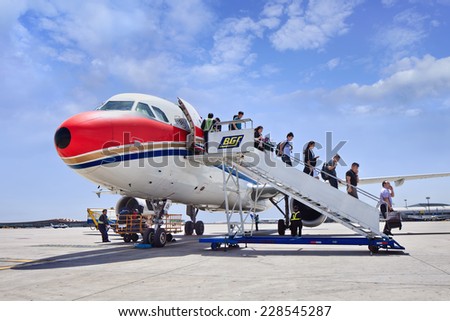 BEIJING-MAY 27, 2014. Passengers come out airplane on Beijing Airport. China\'s economy is now the world\'s second biggest and amid population of over 1.3 billion, a growing middle class want to travel.
