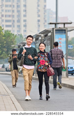 BEIJING-OCT. 19, 2014. Fashionable young couple. According research, Chinese consumers younger than 28 are that future optimistic having zero savings, spending everything on fashion and electronics.