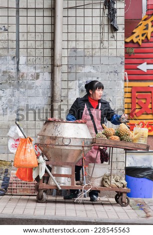 CHONGQING-OCTOBER 30, 2014. Female vendor sells street food. Chongqing is a paradise of food because of various exotic, spicy snacks. Street food is offered at numerous places throughout the city.