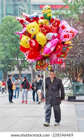 CHONGQING-NOV. 4, 2014. Street vendor with colorful balloons. Migrant workers, the bulk of millions of street vendors often hawk wares without permit and face residency restrictions in bigger cities.