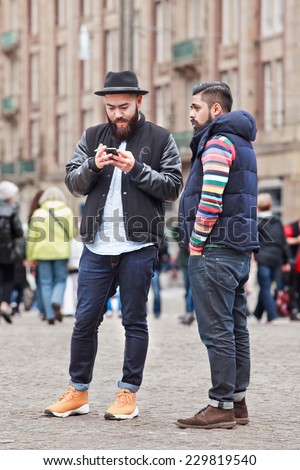 AMSTERDAM-AUGUST 26, 2014. Trendy Asian tourists on Dam Square. Amsterdam is the most visited Dutch city (4.3 million foreign guests). Several times a week events are being organized on Dam Square.