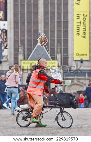 AMSTERDAM-AUG. 26, 2014. Hare Krishna on fold-able bicycle at Dam Square. Hare Krishna is a religious movement based on traditional Hindu scriptures, founded in 1965 by Bhaktivedanta Swami Prabhupada.
