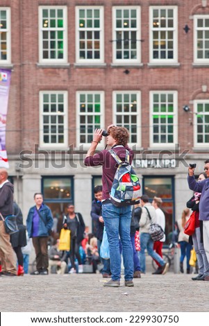AMSTERDAM-AUGUST 26, 2014. Tourist photographing on Dam Square. Amsterdam is the most visited Dutch city (4.3 million foreign guests). Several times a week events are being organized on Dam Square.