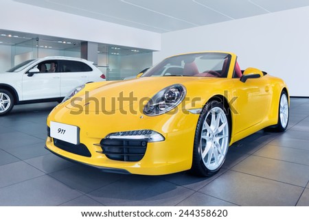 WENZHOU-CHINA-NOV. 19, 2014. Yellow Porsche 911 in showroom. US as Porsche\'s largest single market might end in 2015, China will replace it, predicts Porsche head sales and marketing Bernhard Maier.