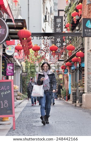 SHANGHAI-DEC. 4, 2014. Young woman at Tianzefang art area. Known for its small craft stores, coffee shops, trendy art studios and narrow alleys it became a popular tourist destination in Shanghai.