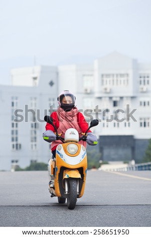 WENZHOU-NOVEMBER 17, 2014. Woman on an e-bike. Estimated 200 million Chinese now use e-bikes,  1,000-fold increase from 15 years ago. About 90 percent of world\'s e-bikes were sold in China in 2012.