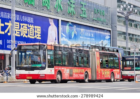 KUNMING-JULY 5, 2014. Billboards and bus with an advert. China\'s outdoor advertising market has grown annually over 23% since 2000, versus 17% for overall ad market, 14% for TV and 16% for newspapers.
