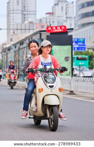KUNMING-JUNE 30, 2014. Girls on an e-bike. An estimated 200 million Chinese now use e-bikes, 1,000-fold increase from 15 years ago. About 90 percent of world\'s e-bikes were sold in China in 2012.
