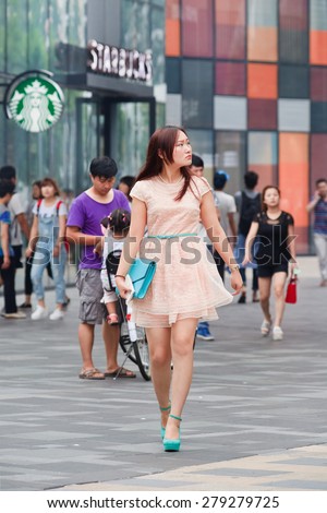 BEIJING-JULY 25, 2014. Self-confident, well dressed young woman at Village shopping area. Over 27 and unmarried females in China are labelled as leftover women, but many of them are happy being single