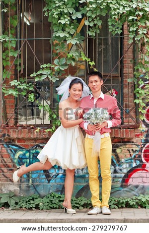 BEIJING-AUG. 7, 2011. Wedding couple against old brick wall. Marriage in China has undergone change during country\'s reform, major change is freedom to choose partner instead an arranged marriage.