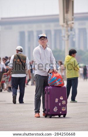 BEIJING-JUNE 1, 2015. Tourist with suitcase on Tiananmen Square. In 2014, China received 3,846 million tourists. They brought revenue of CNY 3,380 billion, an increase of 14.7% compared with 2013.