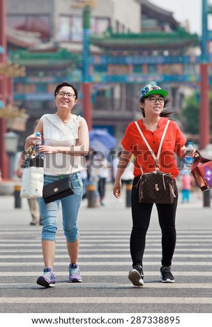 BEIJING-JUNE 9, 2015. Two girls with water bottle. Tap water in China isn\'t drinkable but bottled mineral water and various beverages are commonly sold in street shops and supermarkets, for about CNY3
