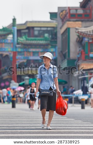 BEIJING-JUNE 9, 2015. Well-dressed elder woman. Elderly population (60 or older) in China is about 128 million, one in every ten people, world\'s largest. China will have 400 million elderly by 2050.