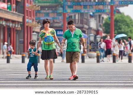 BEIJING-JUNE 9, 2015. Chinese couple with child. China's one-child policy, initiated late 1970s - early 1980s was to limit families have one child to reduce growth rate of China's enormous population.