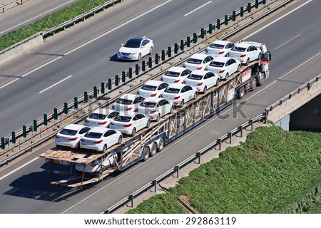BEIJING-JUNE 30, 2015. Over sized car carrier. These illegal car trailers have lengths up to 40m and carry often over 20 cars while a normal car carrier would likely carry no more than 8 to 10 cars.