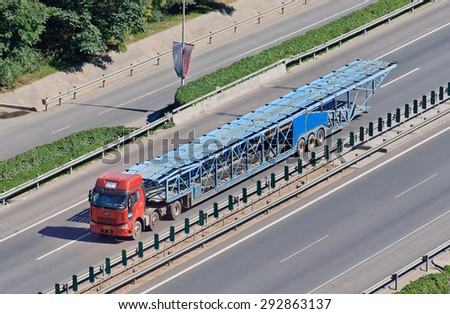 BEIJING-JUNE 30, 2015. Over sized car carrier. These illegal car trailers have lengths up to 40m and carry often over 20 cars while a normal car carrier would likely carry no more than 8 to 10 cars.