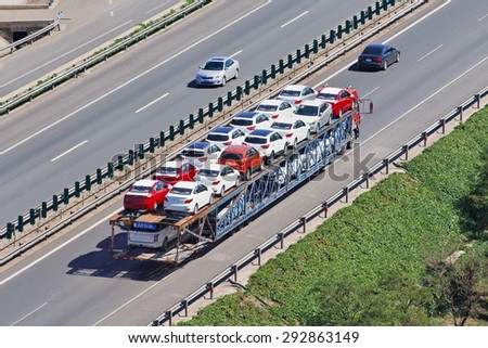 BEIJING-JUNE 30, 2015. Over sized car carrier. Although 16.5m is China\'s official truck length, a large number of vehicle carriers operate in open violation of the maximum length and overhang rules.