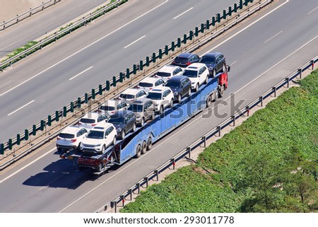 BEIJING-JUNE 30, 2015. Over sized car carrier. Although 16.5m is China\'s official truck length, a large number of vehicle carriers operate in open violation of the maximum length and overhang rules.