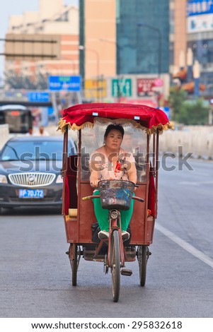 BEIJING-JULY 10, 2015. An electric motorized rickshaw. In Chinese cities rickshaws are still a popular and affordable transport mode for short distances, currently they are all electric motorized.