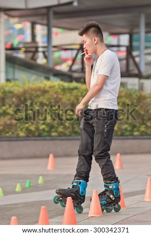 BEIJING-JULY 24, 2015. Cool guy practicing skating. Although Ping-Pong, basketball and badminton are China\'s top sports, last decade inline skating became increasingly popular among Chinese youth.