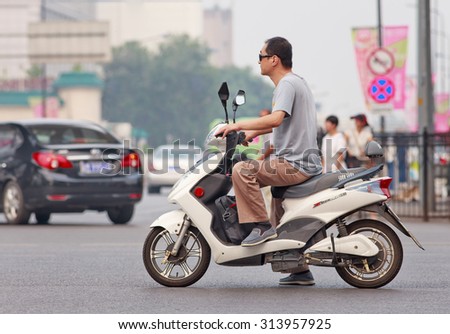 BEIJING-JULY 27, 2015. Man on new e-bike. In a decade, e-bikes in China climbed from near zero to over 150 million by 2015, the largest adoption of alternative fuel vehicle in history of motorization