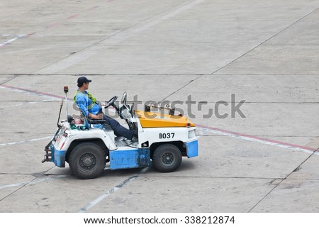 BEIJING-MAY 23. 2014. Nissan tow tractor for baggage dolly transport on Beijing Airport. Speed, efficiency, and accuracy are essential in ground handling services to minimize the turnaround time.