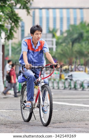 ZHUHAI-CHINA-SEPTEMBER 5, 2013. Young worker on his bicycle in the city center. Article 15 of the (PRC) Chinese Labor Law (1994) prohibits the employment of persons under the age of 16 years.