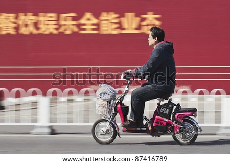 BEIJING - OCT. 25: Man on electric bicycle in Beijing, Oct. 25, 2011. Currently, many Beijing residents buy battery-powered two wheel bikes to avoid wasting time on congested streets.
