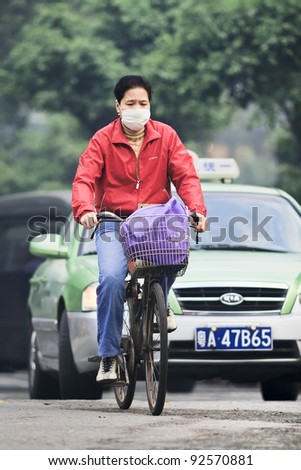 GUANGZHOU - JAN. 8, 2008. Cyclist with mouth cap on Jan. 8, 2008. China\'s environmental protection ministry\'s report Nov. 2010 shows a third of 113 Chinese cities fails to meet national air standards.