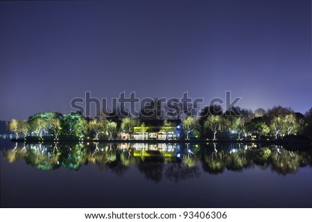 Scenery reflected in a quiet West lake at night.