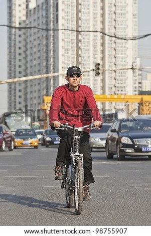 BEIJING-MARCH 27, 2012. Man cycles in Beijing downtown on March 27, 2012 in Beijing. Increasingly Beijing citizens prefer cycle because of congestion. The city has 5 million cars at the end of 2012.