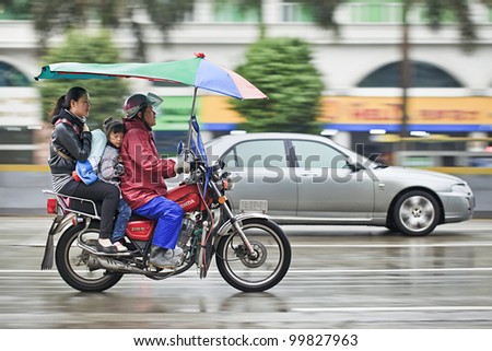 GUANGZHOU-FEB. 25, 2012. Honda motorcycle taxi in the rain on Feb. 25, 2012 in Guangzhou. Honda was founded at 24 September 1948 and has been the world\'s largest motorcycle manufacturer since 1959.