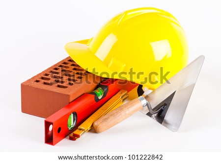 brick, yellow hard hat and tools  on white background