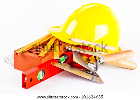 brick, yellow hard hat, tools and construction plans isolated on white background