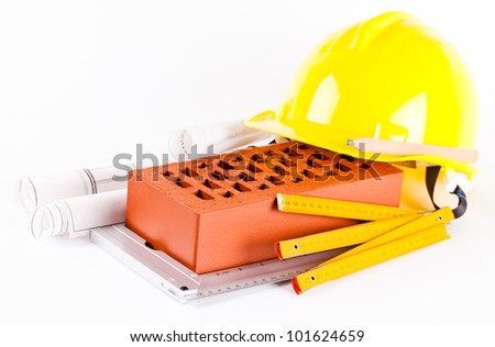 brick, yellow hard hat, tools and construction plans isolated on white background