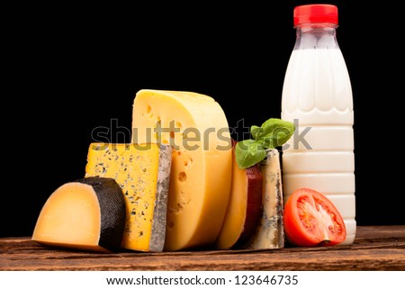 Various types of cheese milk and vegetables isolated on black