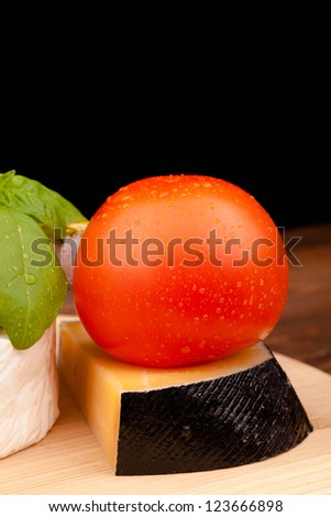 tomato and block of cheese  isolated on black