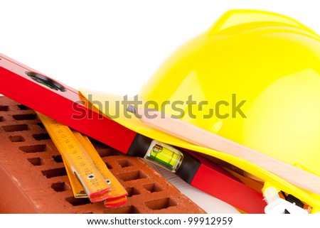 brick, yellow hard hat and tools  isolated on white background