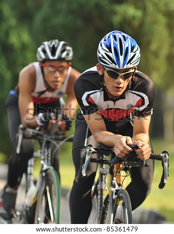 KUALA LUMPUR, MALAYSIA- SEPT. 24: An unidentified participant cycles after run 5km at  Malakoff  University Duathlon Series  2011, on September 24, 2011 in Kuala Lumpur, Malaysia