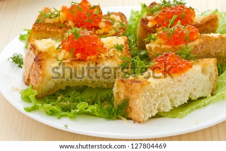 Fried toast with cheese and red caviar, greens
