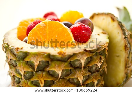 salad of pineapple, oranges and other fruits in a pineapple