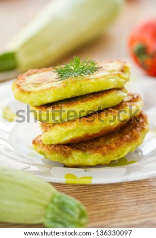 zucchini pancakes on a plate with greens