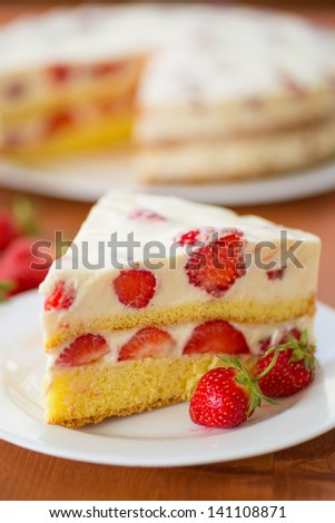 strawberry cream cake on a plate on a wooden table