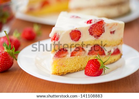 strawberry cream cake on a plate on a wooden table