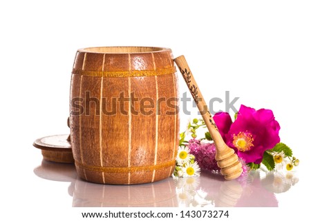 Flower honey in a barrel and flowers on a white background
