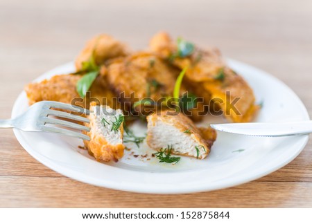 chicken fried in batter with dill on a plate