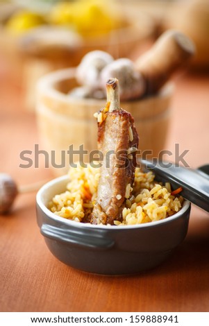 pilaf with rice and meat in a bowl on a wooden table
