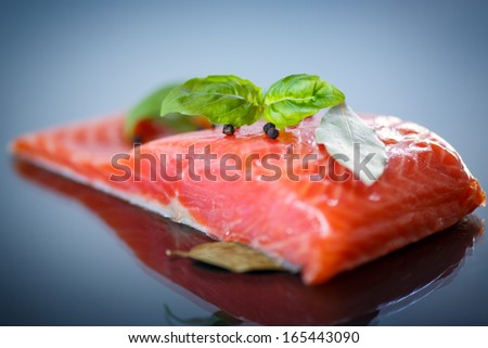salted red fish with greens on a dark background